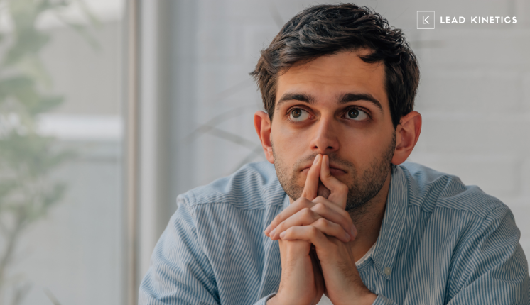 A thoughtful business professional sitting at a desk, reflecting on marketing decisions, representing a business owner considering whether to hire a freelancer or a marketing agency.