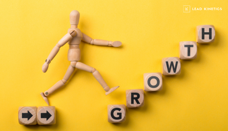 A wooden mannequin figure walks upward across wooden blocks spelling the word “growth” on a yellow background. The image visually represents business expansion and marketing scalability, perfectly aligning with the Lead Kinetics blog about growing marketing capacity without increasing headcount.
